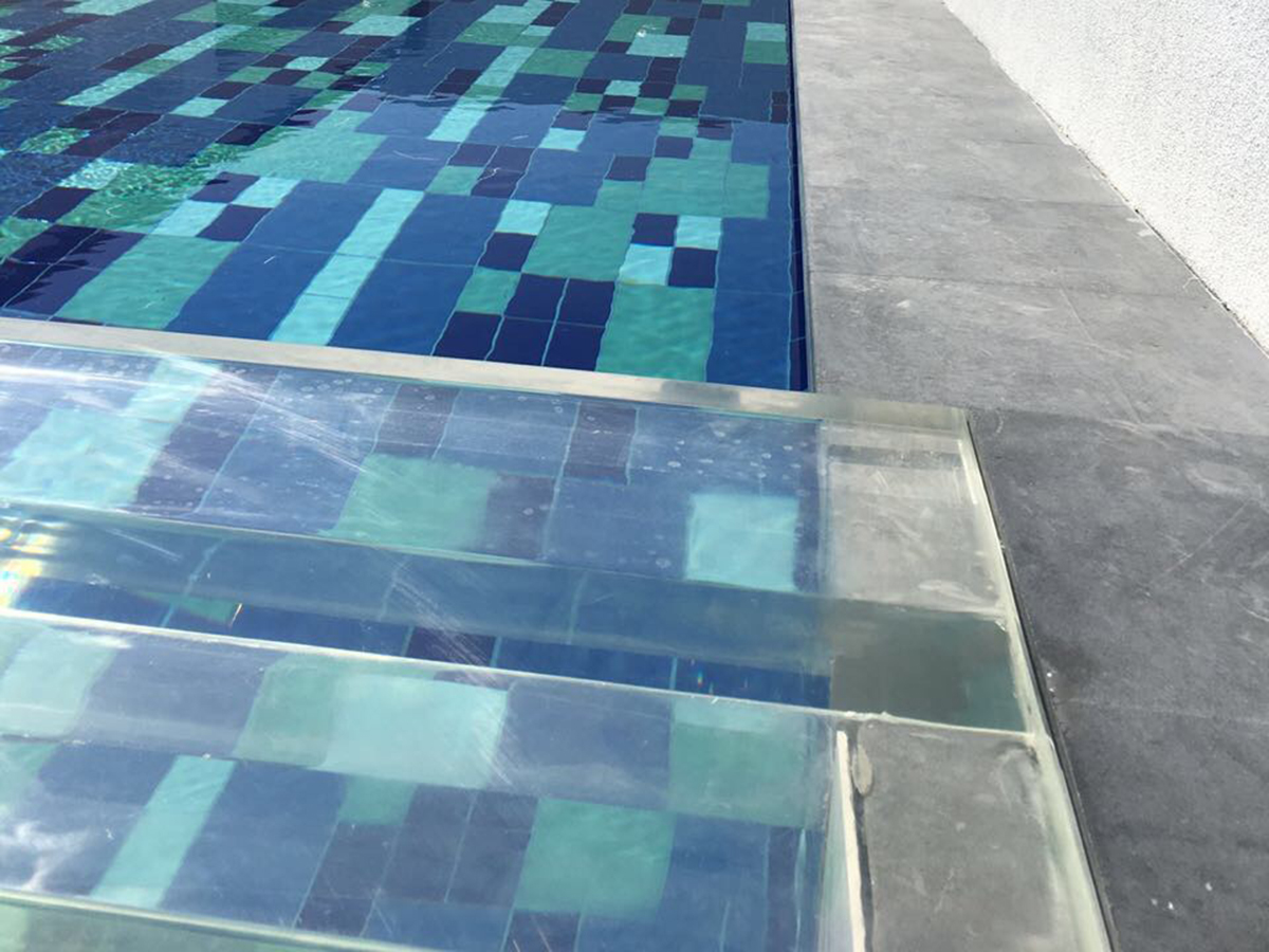 Acrylic pool panel top edge and interface detail — rooftop pool, Dubai, showing panel-to-deck junction and sealant joint condition