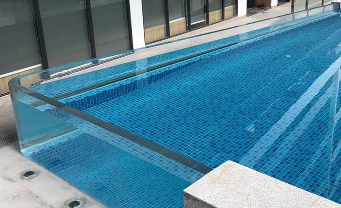 Completed acrylic pool viewing wall — hotel rooftop pool, Vietnam, showing full panel span, curved corner, and water depth