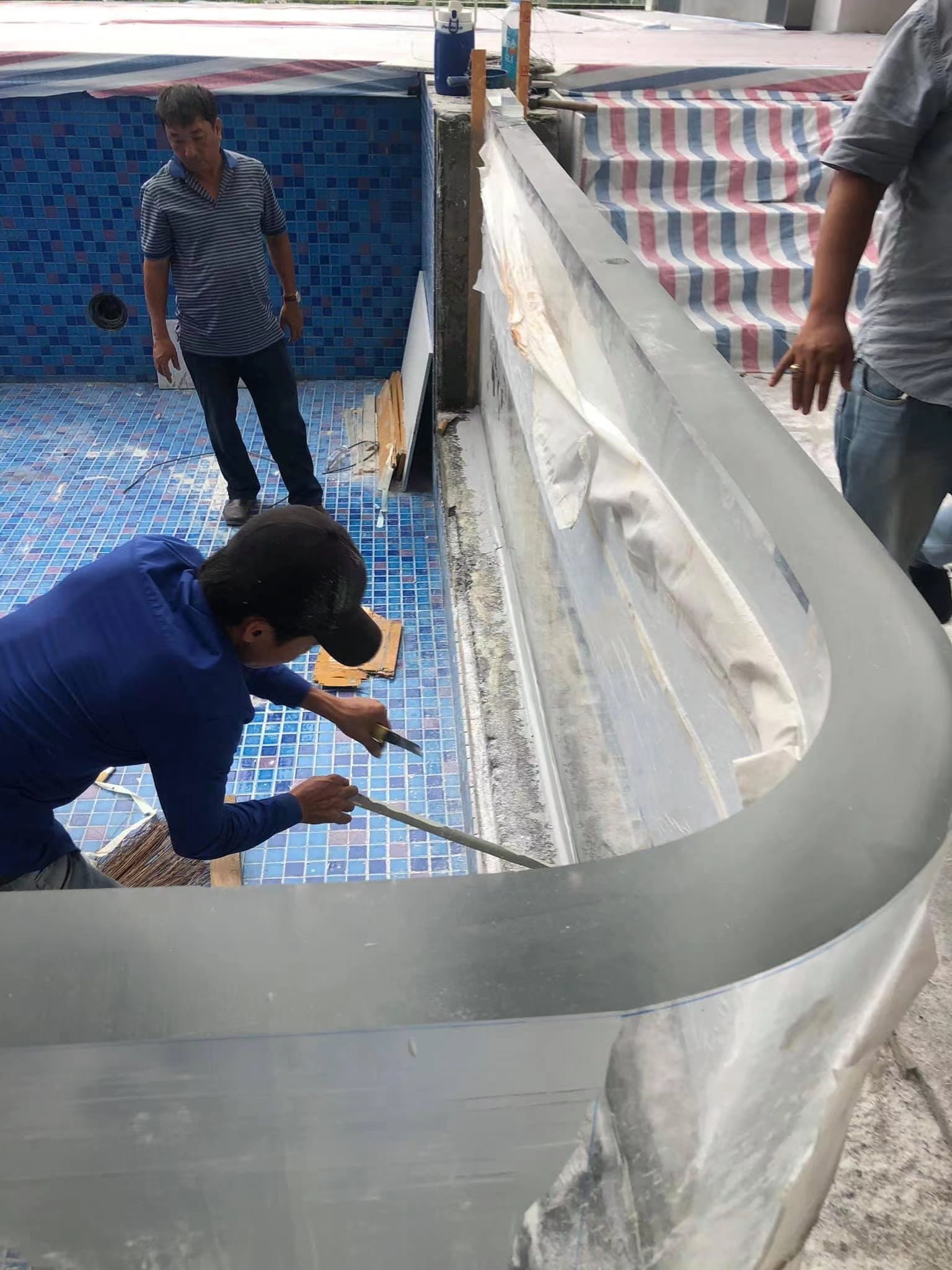 Acrylic panel installation positioning stage — panel being seated in frame with lifting equipment, installation sequence and joint alignment visible
